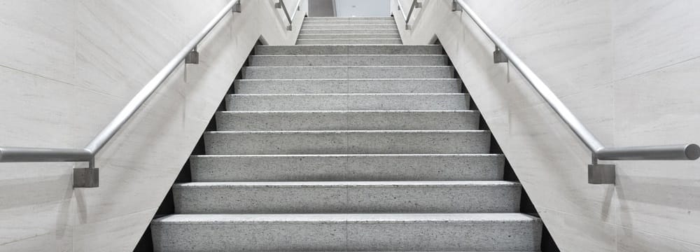 Escada em revestimento de piso normal, com corrimão dos dois lados