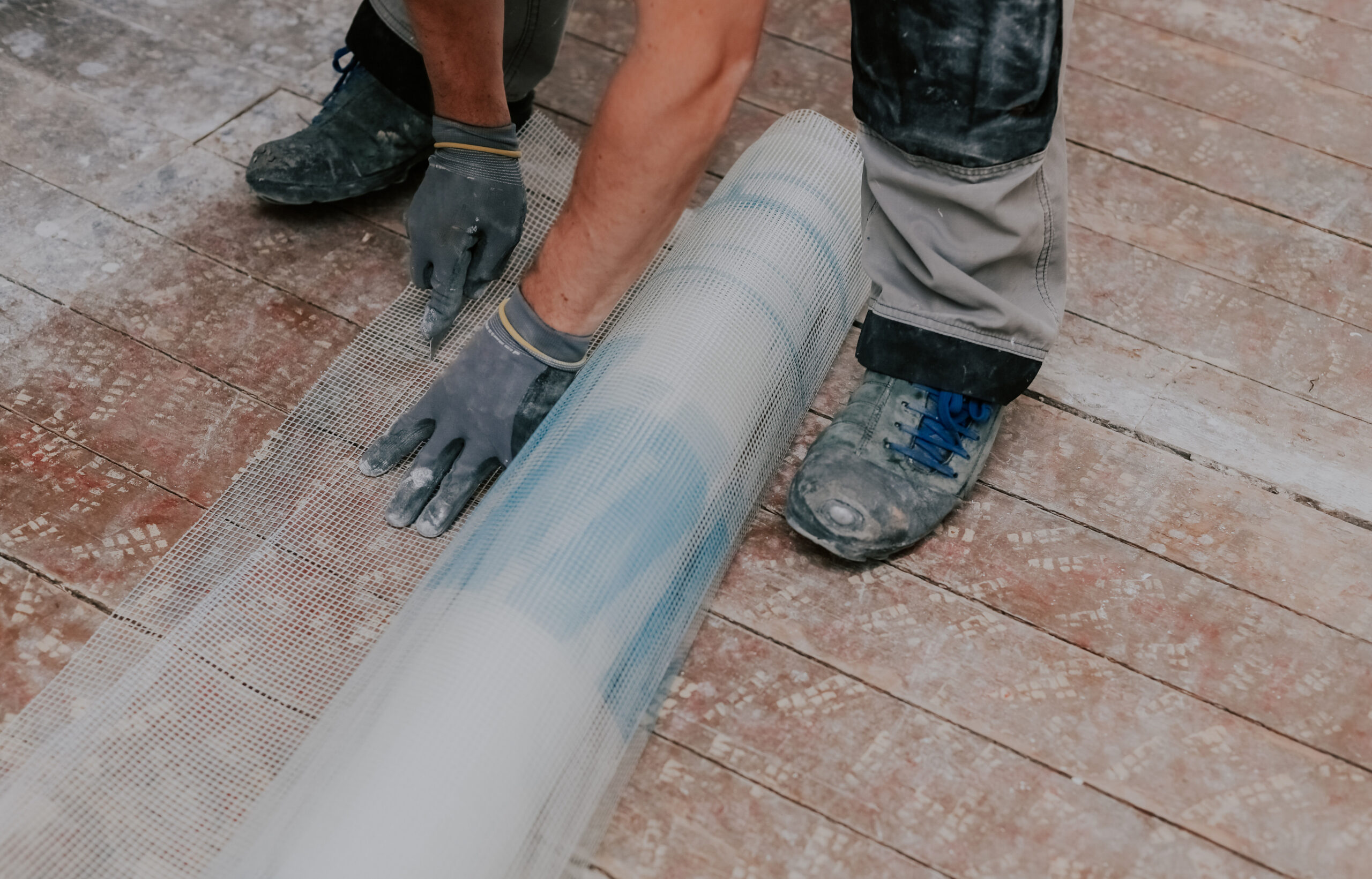 Profissional aplicando malha impermeabilizante em área externa