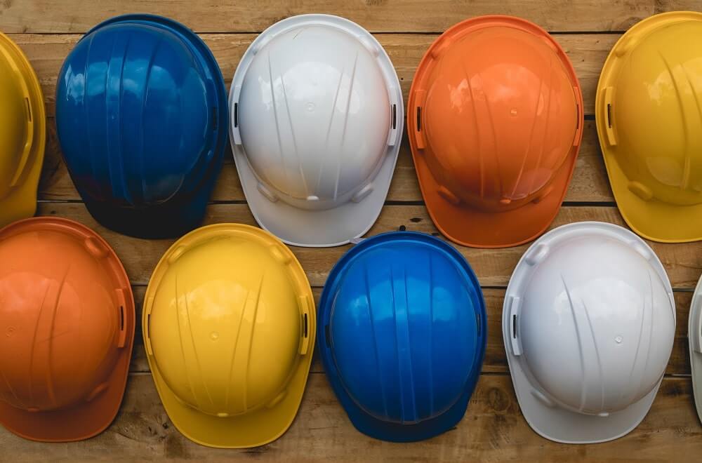 Diversos capacetes de obras na mesa