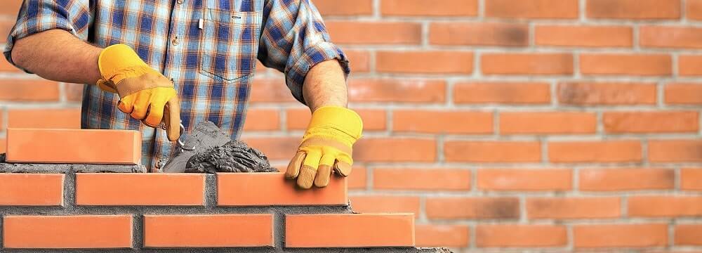 Profissional assentando tijolos com argamassa